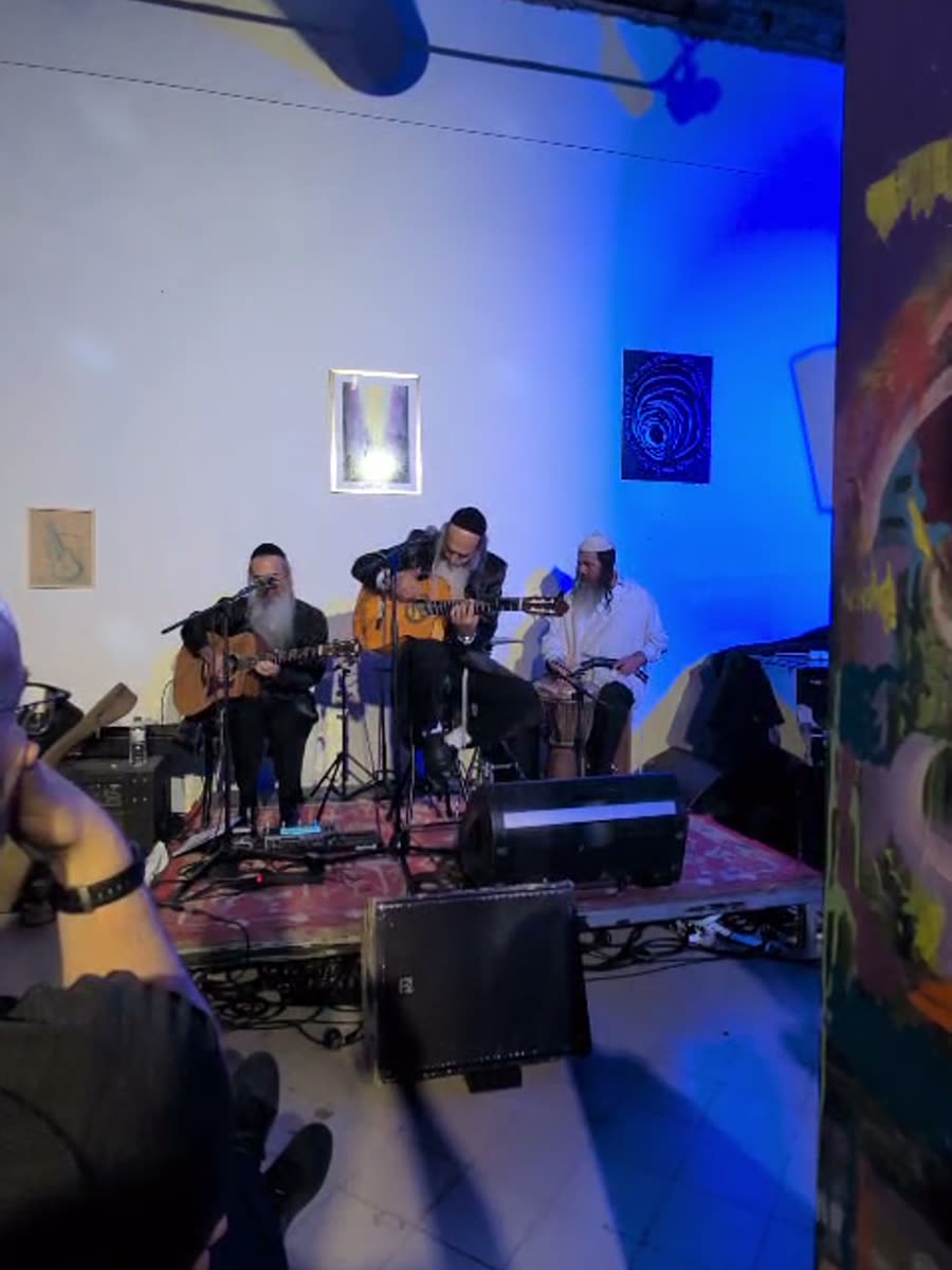 Musicians performing in a purple-lit hall
