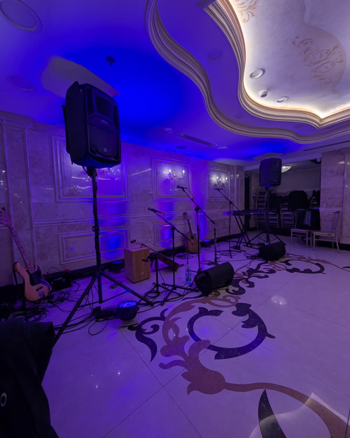 Speakers and monitors on a dance floor lit in purple